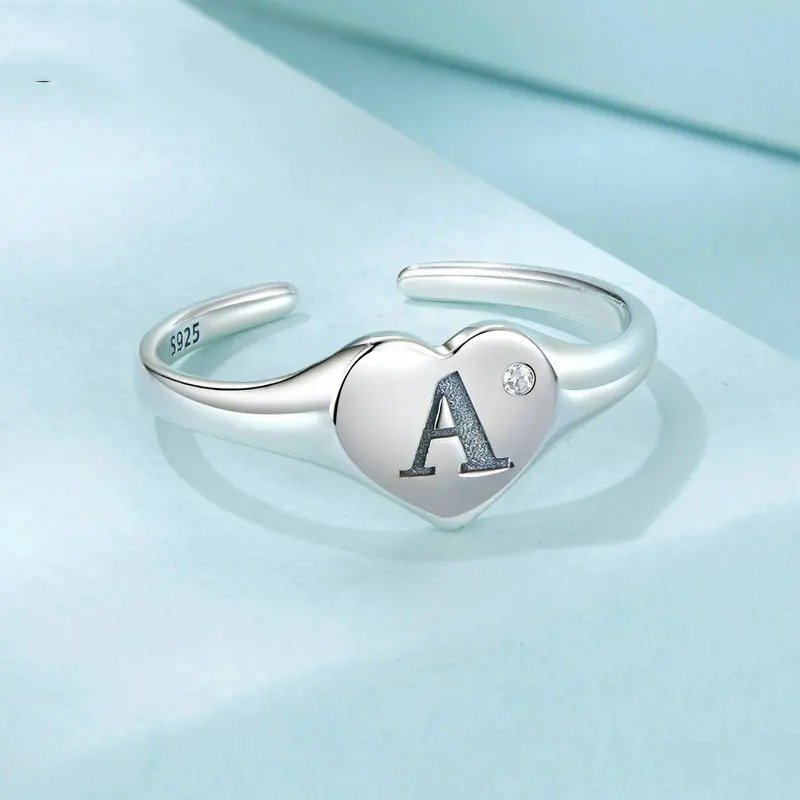 Anillo abierto con letra inicial A grabada, ajustable y apilable en forma de corazón.