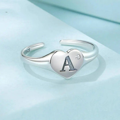 Anillo abierto con letra inicial A grabada, ajustable y apilable en forma de corazón.